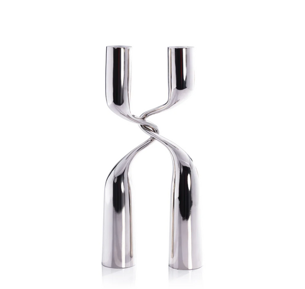The Zodax Interlock Candle Holder in polished nickel features two twisted stems forming an X-like design, ideal for modern décor and shown elegantly against a white background.