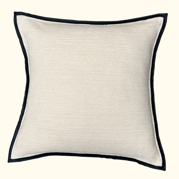 The Threads Soft Goods Leather Frame Pillow Ivory is a square ivory accent pillow featuring subtle textured fabric and a slim leather border, displayed against a light background.