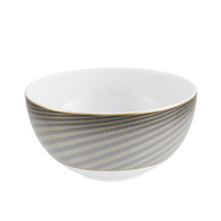 The Oskar Dinnerware bowl by Raynaud features white Limoges porcelain with blue and gold diagonal geometric stripes around the outside, a gold rim, and a plain white interior.