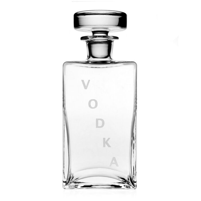 The William Yeoward Lillian Decanter Vodka is a clear handmade crystal glass decanter with a round stopper and VODKA vertically in frosted letters on the front, set against a plain white background.