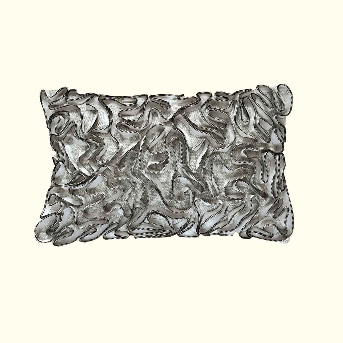The Threads Soft Goods Zipper Pillow Natural 13 x 20 features sheer, mesh-like fabric and wavy black-edged ruffles for a textured look that stands out beautifully against a light beige background.