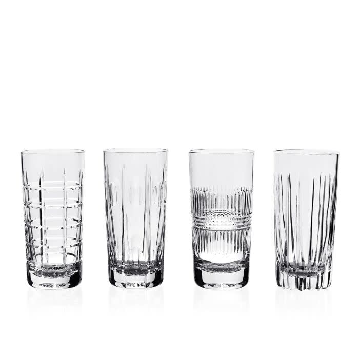 The Skye Drinkware Set of 4 by William Yeoward features clear glass tumblers, each with a unique etched design—horizontal lines, vertical cuts, or crosshatch patterns—displayed in a row against a white background.