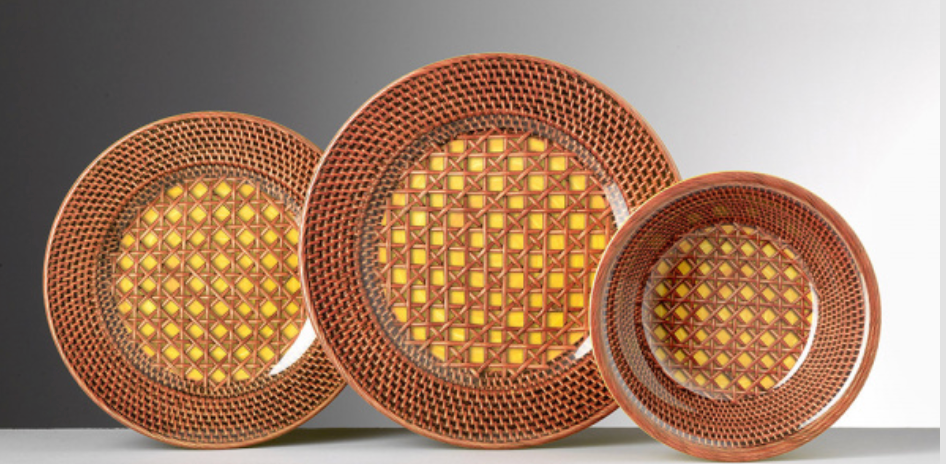 Three melamine bowls from the NEW! Patagonia Yellow Dinnerware by Mario Luca Giusti, Italy, feature textured geometric diamond patterns in orange, yellow, and brown tones, arranged in a row on a gradient gray background.