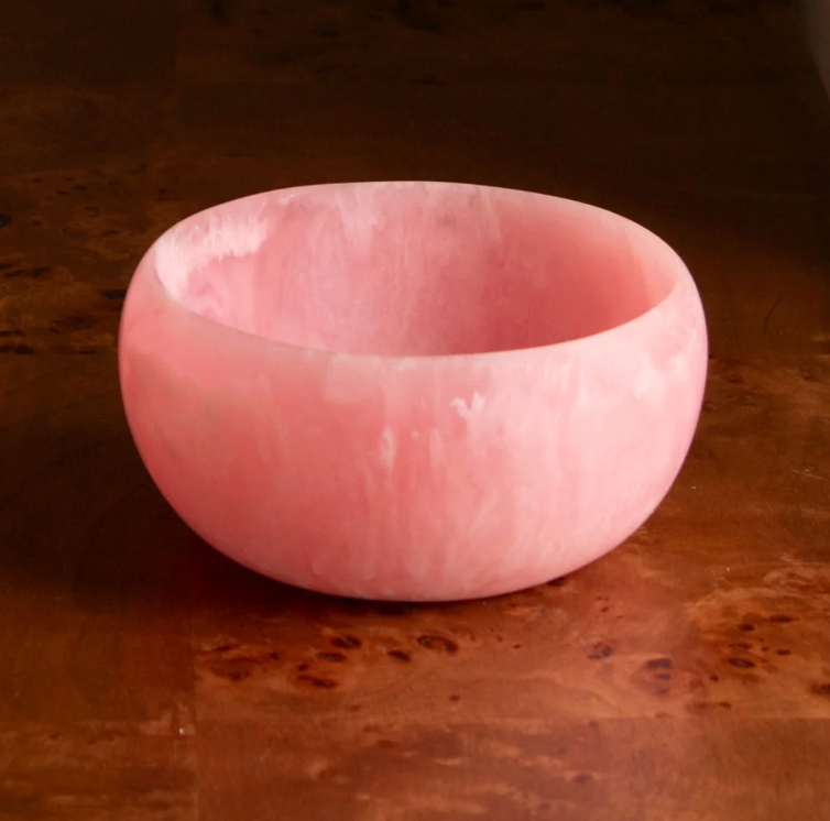 A Resin Sorbet Mini Bowl in Raspberry by Beatriz Ball sits on a polished wooden surface—an elegant gift for hostess occasions.