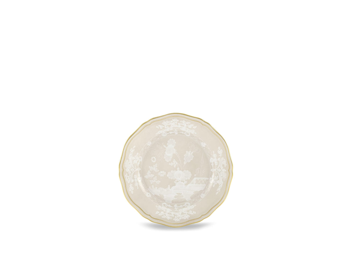 The Ginori 1735 Oriente Italiano Beige Meringa is a decorative porcelain plate with scalloped edges, gold trim, and detailed white floral and classical designs on a light beige background, set against a plain white backdrop.