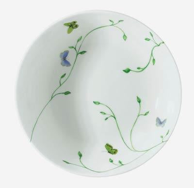The Histoire Naturelle Dinnerware by Raynaud is a white ceramic plate adorned with green vines, rare birds, and butterflies in green, blue, and lavender—an elegant choice to enhance any dining experience.