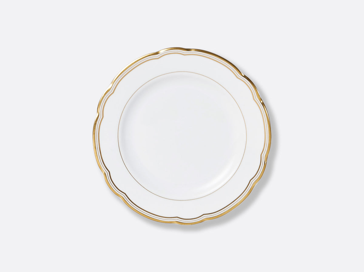 The Bernardaud Pompadour plate is round, white porcelain with a scalloped edge and two gold rims, showcasing classic Limoges craftsmanship. Displayed against a light gray background.