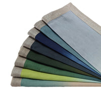 The Dip Dye Napkins - Cool Tones Set of 4 by Kim Seybert features rectangular linen napkins in gradient cool tones, each with a beige woven or metallic foil border.