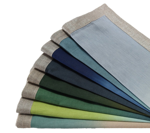 The Dip Dye Napkins - Cool Tones Set of 4 by Kim Seybert features rectangular linen napkins in gradient cool tones, each with a beige woven or metallic foil border.