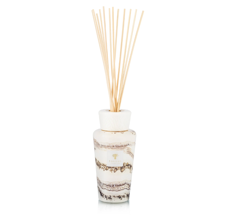 The Baobab Sand Siloli Diffuser features wooden sticks in a white, marbled glass bottle, elegantly displayed on a white background and filling the room with a luxurious fragrance of cedarwood and tonka bean.