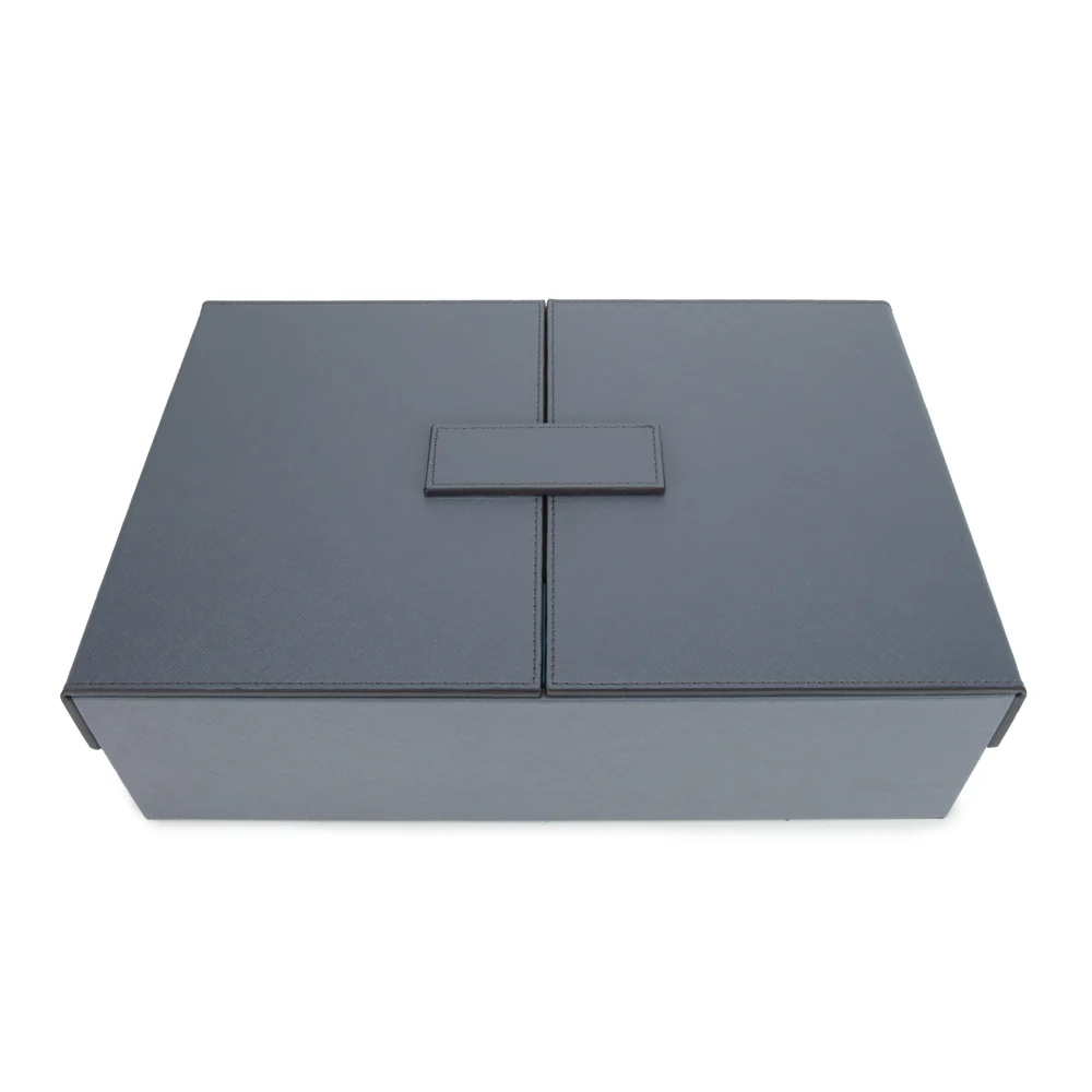 A closed, rectangular Excelsior Steel Grey Rumi Set by Brouk & Co with a central flap and minimalist design rests on a white background—an elegant storage case for your board game set.