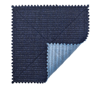 A swatch of Kim Seybert's Vista Reversible Placemat s/4 in Navy & Periwinkle features dark blue textured fabric with zigzag edges, a folded corner revealing a woven lighter blue underside, evoking its reversible design.
