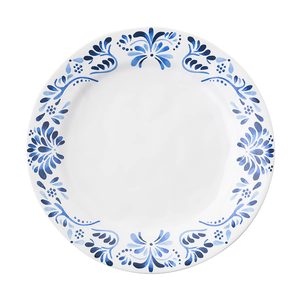 The Juliska Iberian Dinnerware features a round white ceramic dinner plate adorned with a blue floral and leaf pattern inspired by cobalt blue Iberian Journey tiles on a plain white background.
