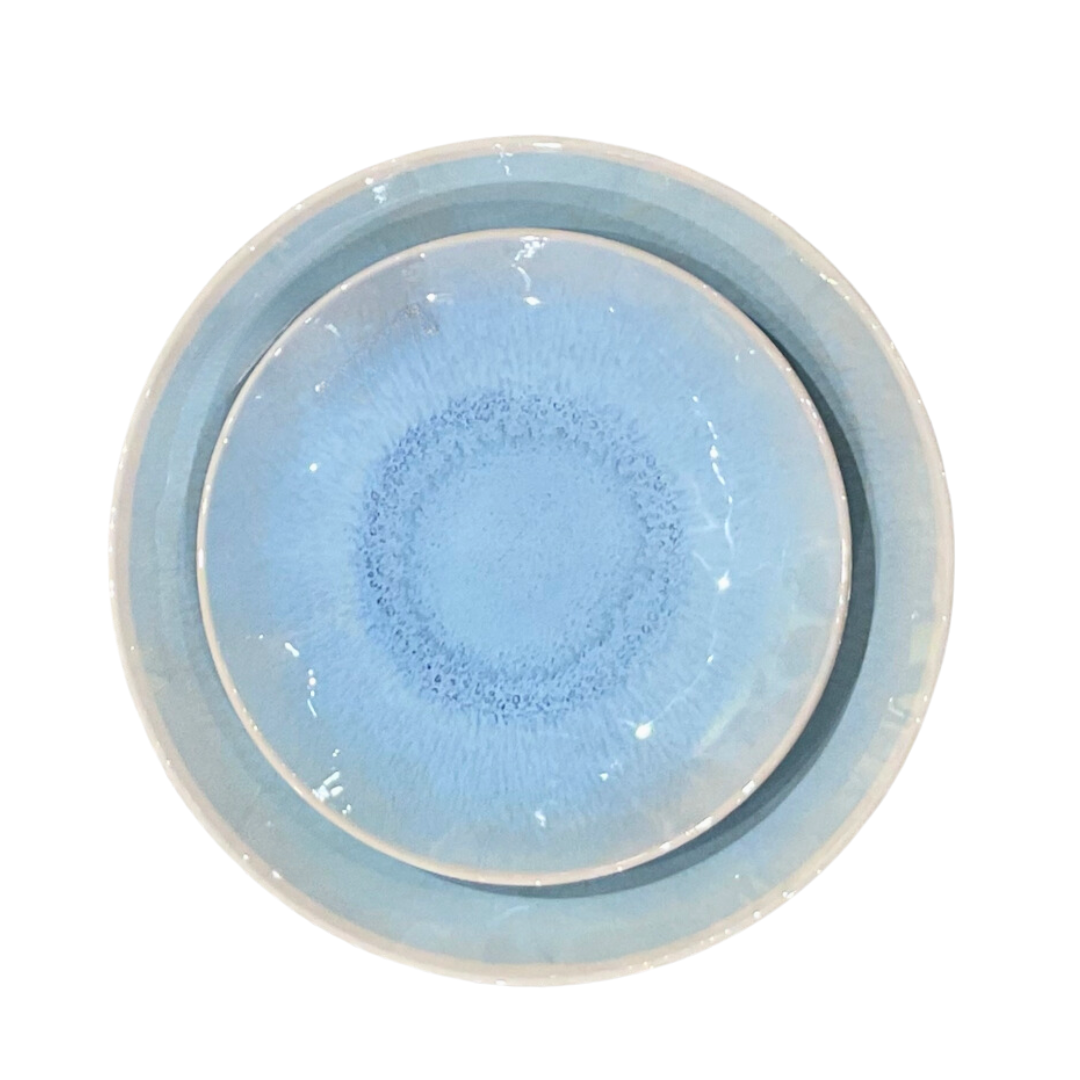 Two round, light blue Merritt Reactive Glaze Melamine Dinnerware plates with white rims are stacked together and viewed from above on a white background—an ideal addition to your collection.