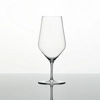The Zalto Water Glass by Grand Cru Selections / Zalto features a clear bowl and thin stem, set on a reflective surface against a plain white background, ready to add elegance to any occasion.