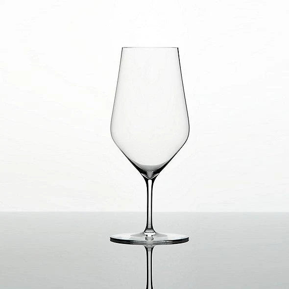 The Zalto Water Glass by Grand Cru Selections / Zalto features a clear bowl and thin stem, set on a reflective surface against a plain white background, ready to add elegance to any occasion.