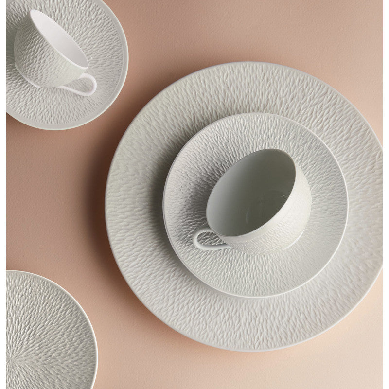 The Registry Dinnerware Fund by Current Home NY features elegant white textured ceramic plates and cups on a pale peach surface—timeless, minimal pieces perfect for any table setting. Click here to select an amount.