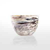 The Nashi Home Swirl Colored Resin Deep Bowl features a marbled pattern in white, beige, brown, and black, shown on a plain white background with a subtle reflection underneath.