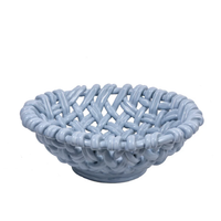 The Skyros Woven Basket - Round-15" is a light blue ceramic bowl with a matte finish and lattice-style design, evoking a handwoven basket. Crafted by Portuguese artisans, it's shown empty against a white background.