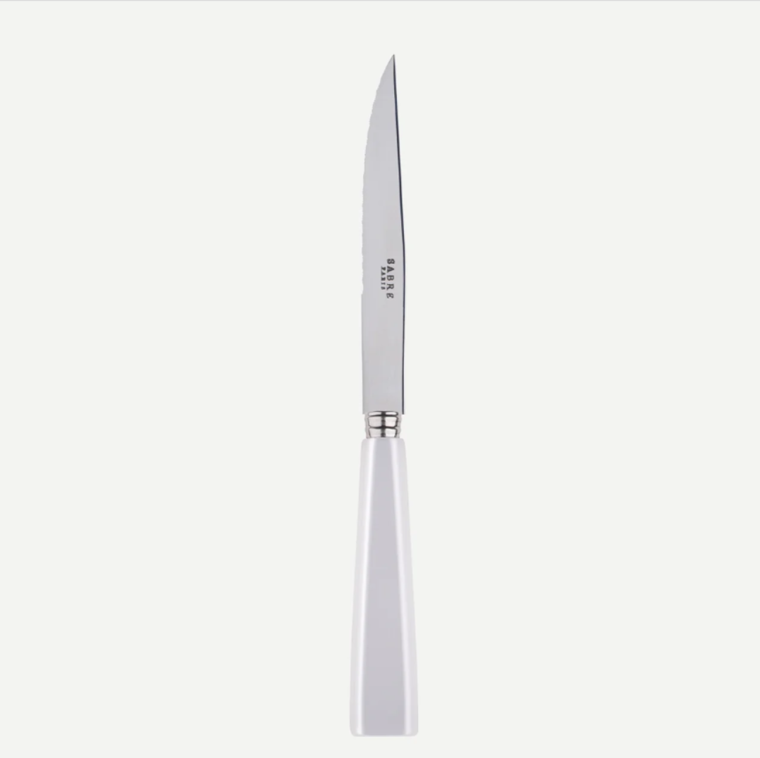 The Sabre Icone 5pps serrated butter knife features a white handle, stainless steel blade with SABRE PARIS engraving, and is dishwasher safe.