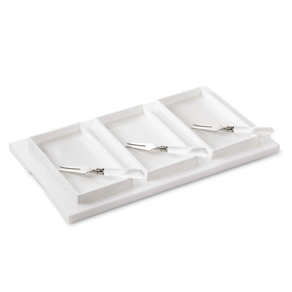 The Inspired Generations Bright White Brunch Board is a rectangular white tray featuring four compartments, each with a small metal knife or spatula sporting a clear handle—an ideal choice for organizing brunch essentials or serving in style at your next gathering.