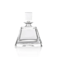 The Zodax Noelle Crystal Decanter features a clear, empty crystal design with a wide base, angled sides, and a square glass stopper. Displayed against a white background, this elegant piece of barware is perfect for elevating your home bar.