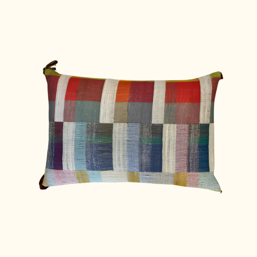 The Lexi Handwoven Pillow 16 x 24 by Threads Soft Goods features a patchwork of colorful red, blue, gray, and yellow squares and rectangles on a light background, inspired by the vibrant textures of handwoven throws.