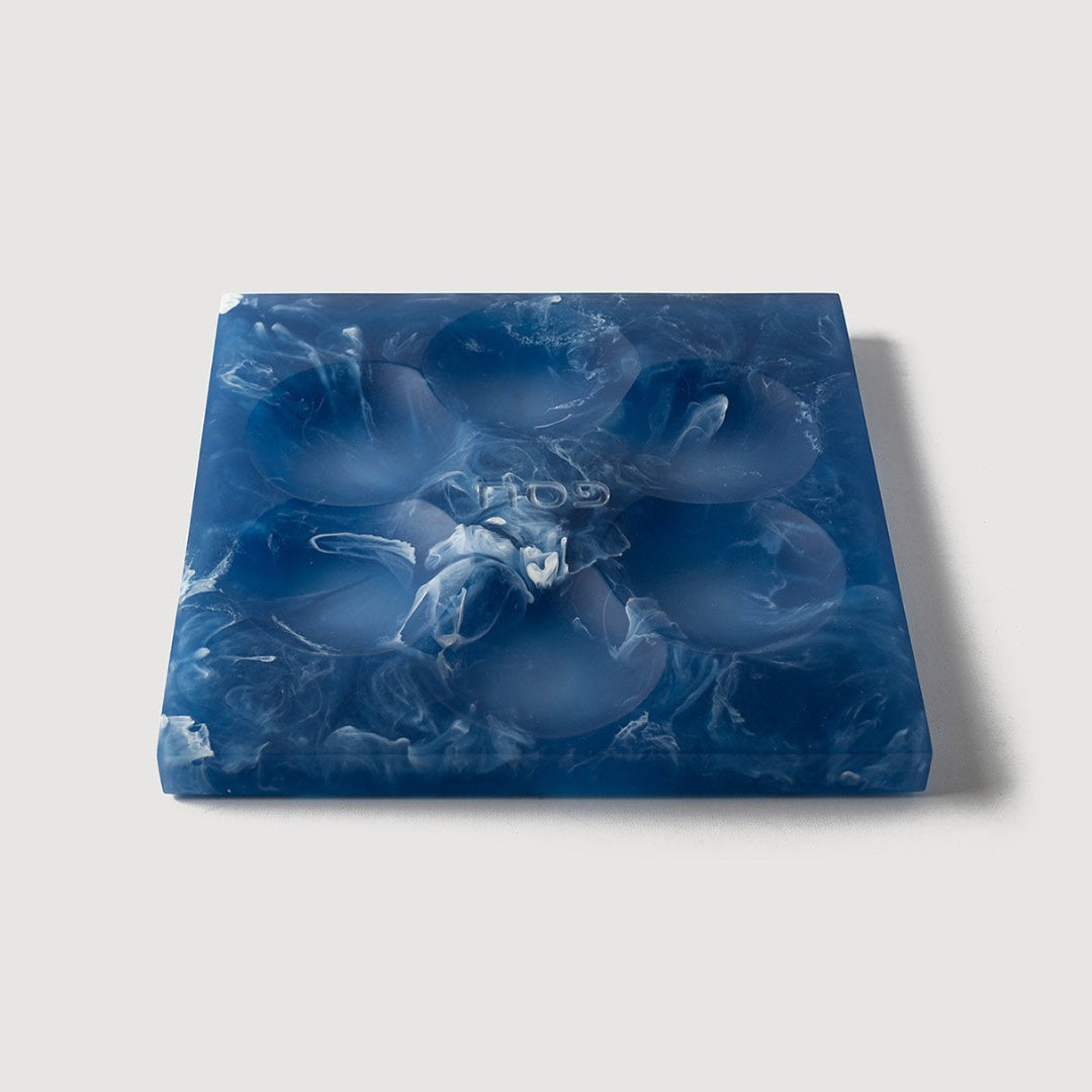 The Resin Seder Plate - NEW! by CDMX / BRUCI features a square blue and white marbled design with six indentations, handcrafted in Mexico—perfect for Passover 2025.