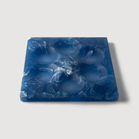 The Resin Seder Plate - NEW! by CDMX / BRUCI features a square blue and white marbled design with six indentations, handcrafted in Mexico—perfect for Passover 2025.