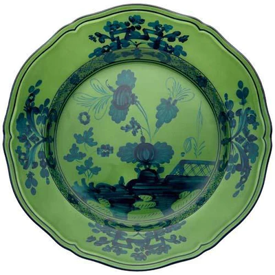 The Oriente Italiano Dinnerware Malachite by Ginori 1735 is a decorative green ceramic plate with scalloped edges, featuring elegant blue floral and botanical patterns for timeless Italian tableware style.