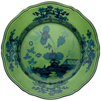 The Oriente Italiano Dinnerware Malachite by Ginori 1735 is a decorative green ceramic plate with scalloped edges, featuring elegant blue floral and botanical patterns for timeless Italian tableware style.