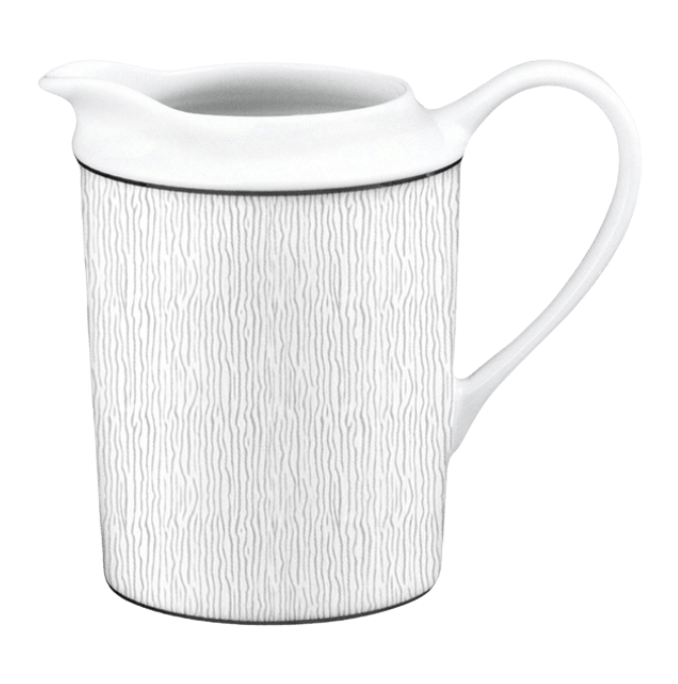 The Bernardaud Dune Dinnerware pitcher features a white ceramic body with a subtle vertical wavy line pattern and a curved handle, reminiscent of Limoges porcelain, displayed against a plain background.