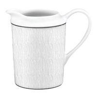 The Bernardaud Dune Dinnerware pitcher features a white ceramic body with a subtle vertical wavy line pattern and a curved handle, reminiscent of Limoges porcelain, displayed against a plain background.