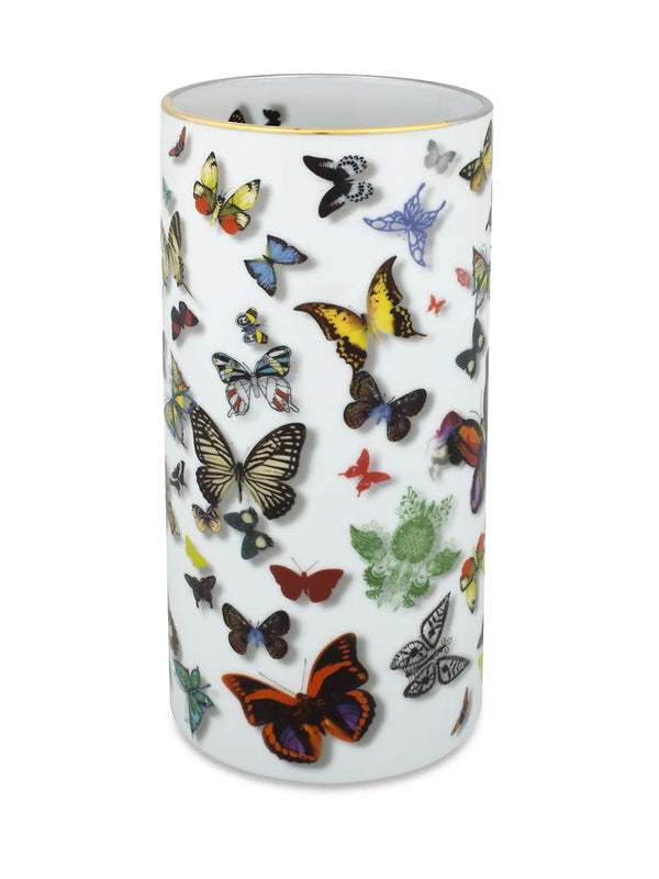 The Butterfly Parade Vase by Christian Lacroix for Vista Alegre is a white cylindrical porcelain vase adorned with vibrant butterfly illustrations in various sizes and species. The rim of this elegant piece features a delicate gold edging.