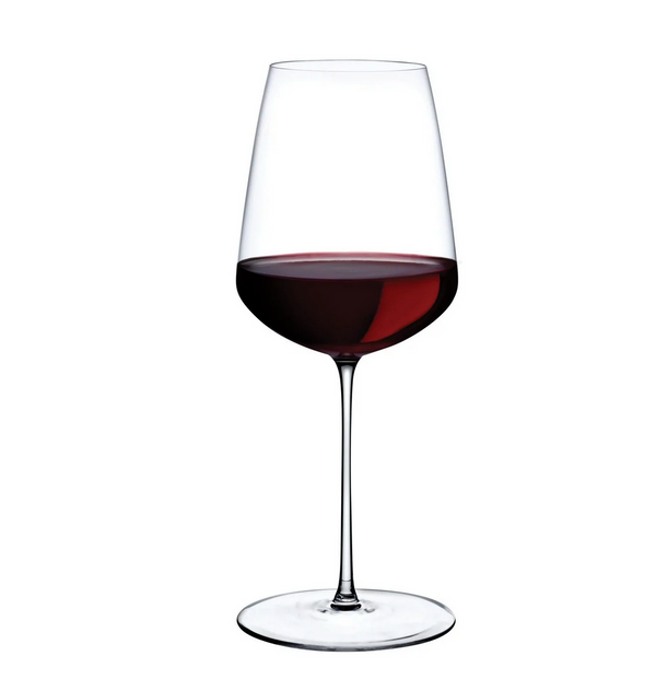 The Stem Zero Powerful Red Wine Glass by Nude Glassware, filled halfway with red wine against a plain white background, highlights the depth and allure of full-bodied reds.