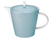 The Raynaud Mineral Irise Dinnerware Sky Blue teapot features a textured light blue ceramic body with white handle, spout, and rim. Made in France, it blends classic charm with modern style and has a small white knob on the lid.