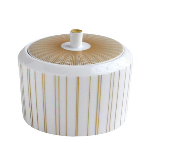 The Sol Dinnerware by Bernardaud is a white Limoges porcelain container with vertical gold lines and a lid adorned with a radiating gold pattern and small cylindrical handle, showcasing refined elegance.