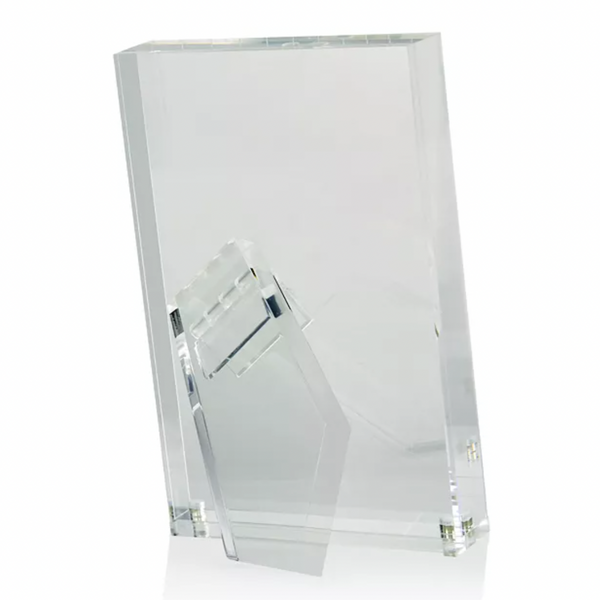The Tizo Lucite Clear Frame is a minimalist, rectangular acrylic picture frame with a transparent support stand, allowing it to stand upright on flat surfaces. The empty frame is displayed against a white background.
