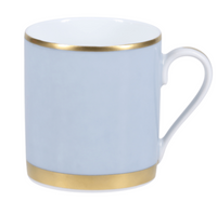 The Recamier Grey & Gold Dinnerware mug by Royal Limoges features light blue porcelain with gold rims, a smooth finish, and a curved handle on the right side.