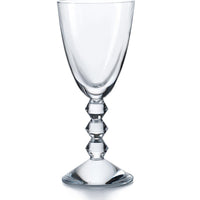 The Baccarat Vega White Wine Glass features a clear bowl and a distinctive stem with three geometric, diamond-shaped segments, set on a round base and shown against a plain white background.