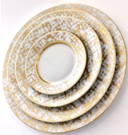 The Tweed White & Gold Dinnerware by Royal Limoges features four white porcelain plates with gold patterns and rims, handcrafted and inspired by timeless French dinnerware traditions.