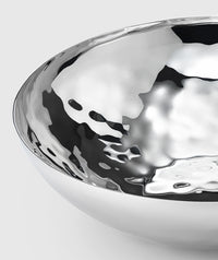 Close-up of the Mary Jurek Luna Serving Bowl 8"—a shiny, reflective stainless steel bowl featuring a smooth curved edge and rippled texture, set against a plain light gray background.