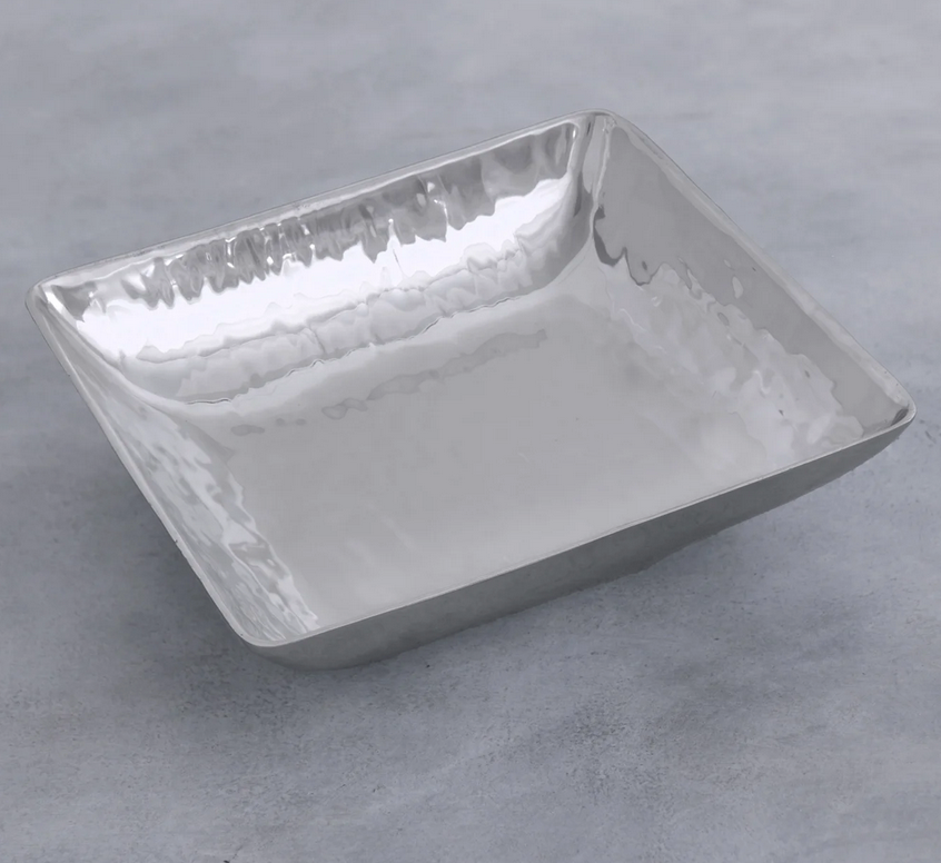 The Beatriz Ball Soho Emerson Square Bowl is a shallow, handmade aluminum bowl with a reflective hammered finish, shown on a light gray textured background.