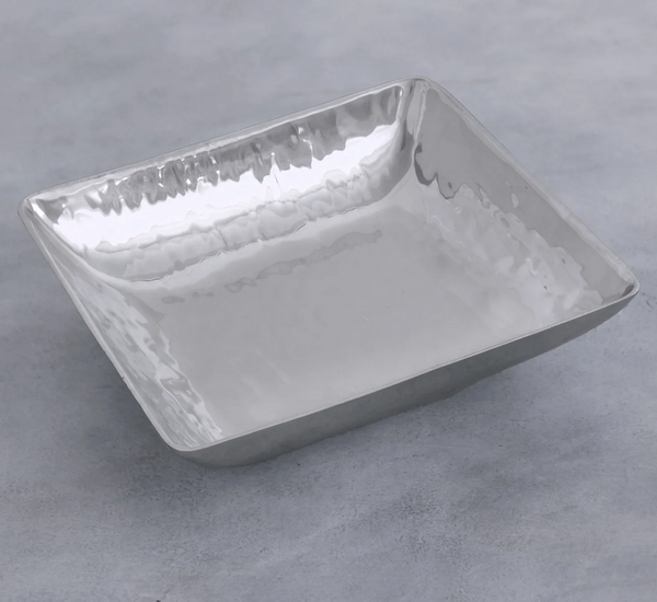 The Beatriz Ball Soho Emerson Square Bowl is a shallow, handmade aluminum bowl with a reflective hammered finish, shown on a light gray textured background.