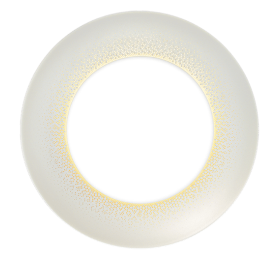 A circular translucent contact lens features a subtle yellow and gold gradient around the inner edge, inspired by Souffle D'or Dinnerware from Haviland. The clear center maintains unobstructed vision.