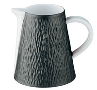 A ceramic jug with a white interior, handle, and spout, plus a textured dark gray exterior with vertical grooves—ideal for pairing with Raynaud’s Mineral Irise Dinnerware - Black.