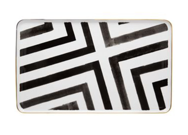 The Sol Y Sombra tray by Christian Lacroix x Vista Alegre features bold black geometric lines on white porcelain, a modern abstract design, slightly rounded corners, and a delicate gold rim.