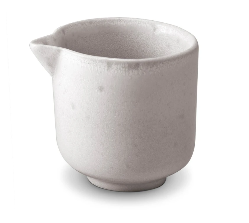 A small, round, light gray ceramic pitcher from L'Objet's Terra Stone Dinnerware collection features a wide opening and short spout, displayed against a plain white background.
