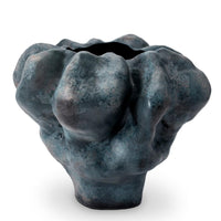 The Timna Vase Short by L'Objet is an abstract ceramic piece with a bulbous, irregular shape and mottled blue-black finish, featuring an organic form, narrow base, and wide undulating rim reminiscent of ancient vessels.