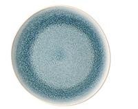 The Rosenthal Junto Aquamarine Dinnerware features a round ceramic plate with a mottled blue reactive glaze, fading from dark at the rim to lighter blue in the center, set against a white background.